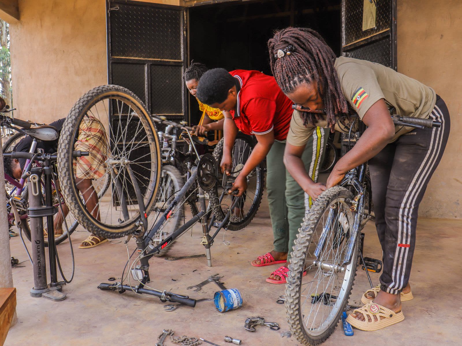 Grupo aprendiendo a reparar una rueda de bicicleta en el taller